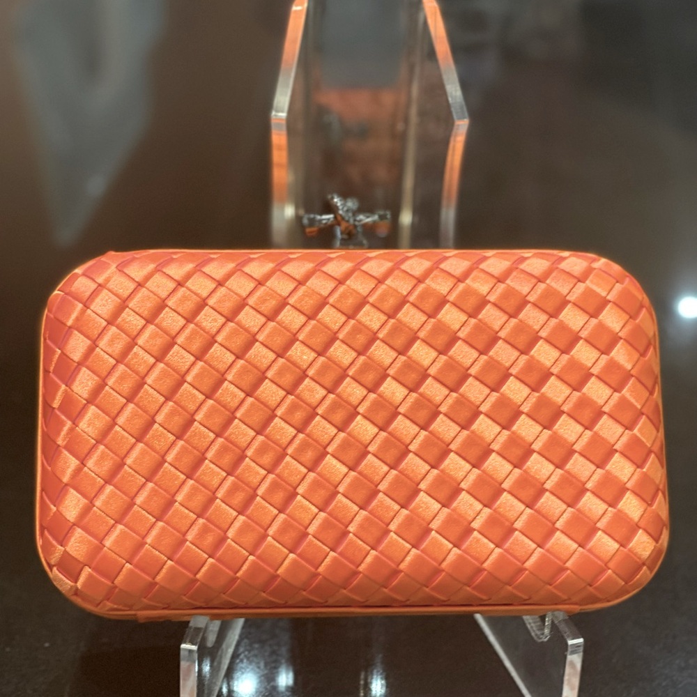 Orange silk weaved clutch comes with strap